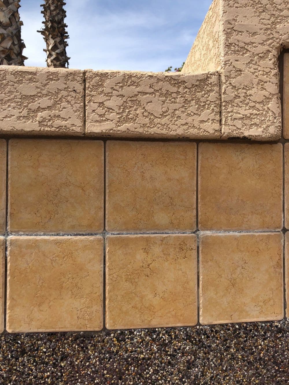 Textured beige tiles on a wall, featuring a warm color palette and clear grout lines.